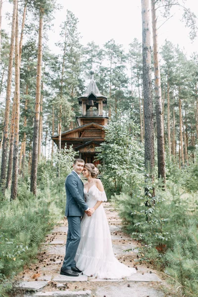 一对时髦的夫妇在一座木制庙宇的背景上 在大自然的森林里举行婚礼 — 图库照片