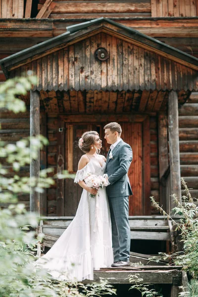 一对时髦的夫妇在一座木制庙宇的背景上 在大自然的森林里举行婚礼 — 图库照片