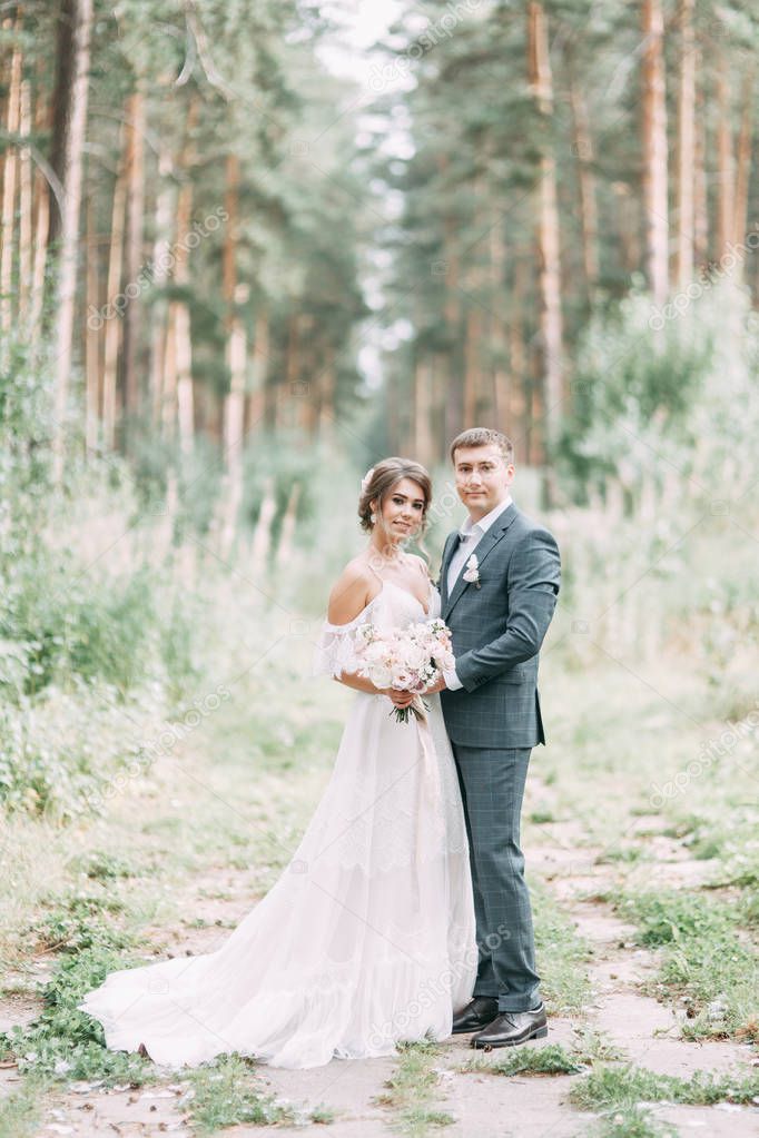 Modern ceremony in European style. Beautiful wedding couple in atmospheric forest with rocks. 