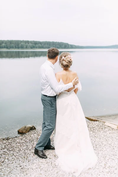 日没時にスタイリッシュなヨーロッパの結婚式 湖の森の中の幸せなカップル — ストック写真