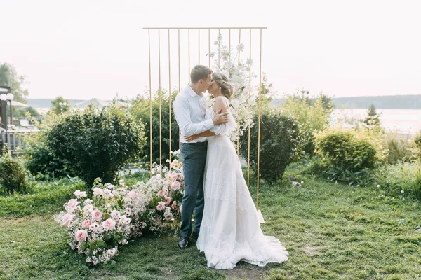 公園の日没時に美しいカップル 森の中のアーチと結婚式 — ストック写真