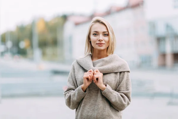 Business portrait on the background of the street. Beautiful girl with smile in town.