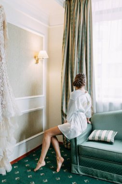 Gelin elbiseyi seçer ve inceler. Stüdyonun duvarında gelinlik var.. 