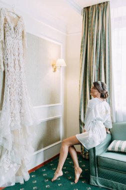 Gelin elbiseyi seçer ve inceler. Stüdyonun duvarında gelinlik var.. 