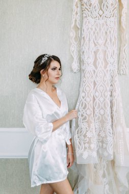 Gelin elbiseyi seçer ve inceler. Stüdyonun duvarında gelinlik var.. 