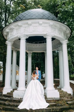 Parkta gün batımında güzel bir çift. Ormanda kemerli düğün töreni.. 