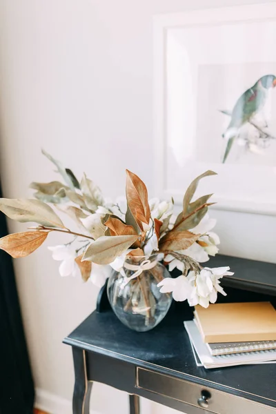 Vase and bouquet of dried flowers on the table. Bright interior details in a modern style.