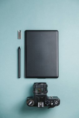 Tablet, kamera ve dizüstü bilgisayarı olan düz bir ev. Fotoğrafçının parlak bir arkaplan üzerindeki minimalist düzeni. 