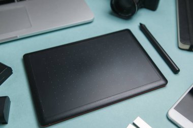 Tablet, kamera ve dizüstü bilgisayarı olan düz bir ev. Fotoğrafçının parlak bir arkaplan üzerindeki minimalist düzeni. 