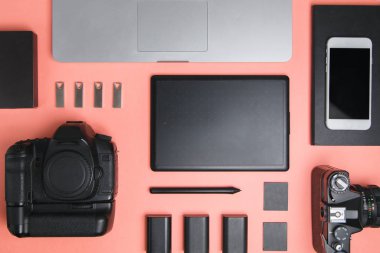Tablet, kamera ve dizüstü bilgisayarı olan düz bir ev. Fotoğrafçının parlak bir arkaplan üzerindeki minimalist düzeni. 
