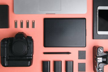 Tablet, kamera ve dizüstü bilgisayarı olan düz bir ev. Fotoğrafçının parlak bir arkaplan üzerindeki minimalist düzeni. 