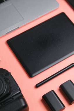 Tablet, kamera ve dizüstü bilgisayarı olan düz bir ev. Fotoğrafçının parlak bir arkaplan üzerindeki minimalist düzeni. 