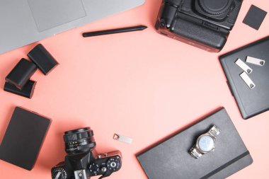 Kameralı, dizüstü bilgisayarı ve telefonu olan düz bir ev. Fotoğrafçının parlak bir arkaplan üzerindeki minimalist düzeni. 