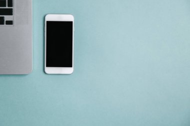 Kameralı, dizüstü bilgisayarı ve telefonu olan düz bir ev. Fotoğrafçının parlak bir arkaplan üzerindeki minimalist düzeni. 