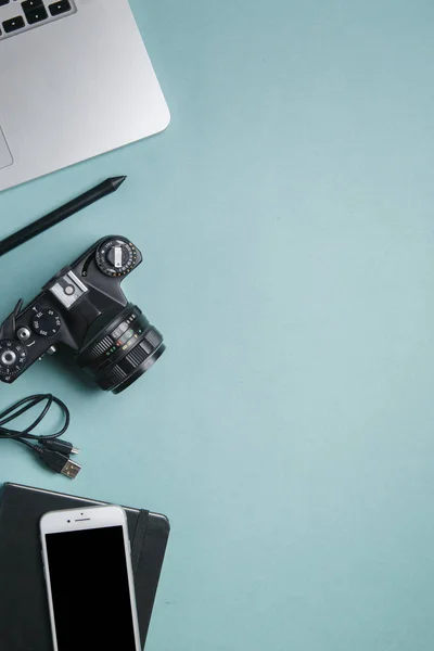 Flatley with camera, laptop and phone. Minimalist layout of the photographer on a bright background.