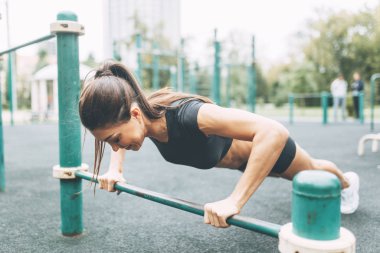 Şınav, antrenman ve kalas. Oyun parkındaki güzel atletik kız..
