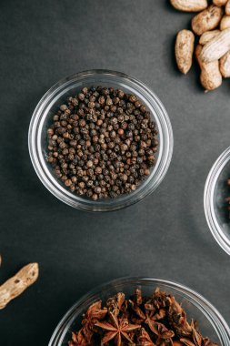 Siyah arka planda baharatlar. Kasede kara biber. 