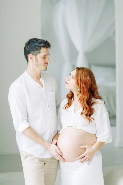 Těhotná Žena Náručí Bílém Šťastný Pár Čeká Dítě — Stock fotografie