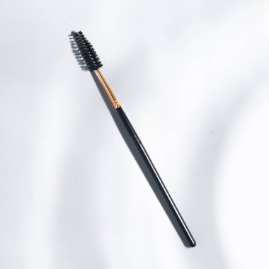 Site için ışıklandırılmış arkaplan. Makyaj sanatçısı için bir alet. Makyaj fırçası. Siyah plastik kaş fırçası. 