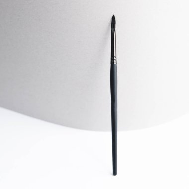 Site için ışıklandırılmış arkaplan. Makyaj sanatçısı için bir alet. Makyaj fırçası. Siyah plastik kaş fırçası. 