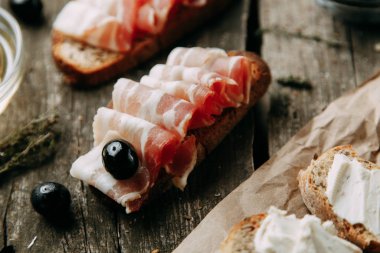 Eski ahşap bir arka planda ekmek. Pastırmalı jambon. Flatley 'nin İtalyan yemekleri.. 