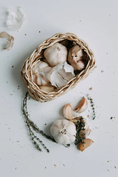 Flatley layout for cooking. Garlic cloves on a white background. Peeled garlic with salt, oil and thyme.