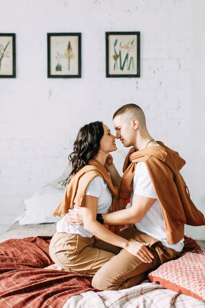 Beautiful couple on the bed. Love story in the interior Studio. Happy and laughing people. At home, having fun on the bed.
