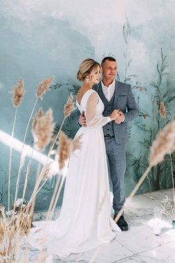 Sonbahar dekoru içinde bir düğün çifti. Odadaki güzel sanatlar tarzında bir seremoni. İç Stüdyoda düğün töreni. 