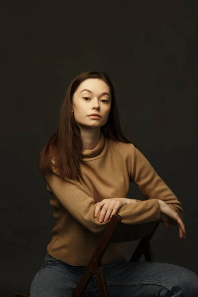 Professional model and posing. Model tests of a girl in a Studio with a black background.