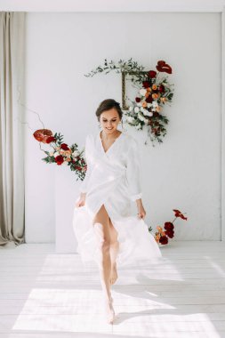 Güllerin kırmızı düğün dekoru. Gelinin portresi güzel sanatlar tarzında. Gelinin kar beyazı stüdyosundaki sabahı. 