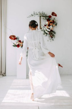 Güllerin kırmızı düğün dekoru. Gelinin portresi güzel sanatlar tarzında. Gelinin kar beyazı stüdyosundaki sabahı. 