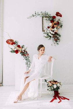 Güllerin kırmızı düğün dekoru. Gelinin portresi güzel sanatlar tarzında. Gelinin kar beyazı stüdyosundaki sabahı. 