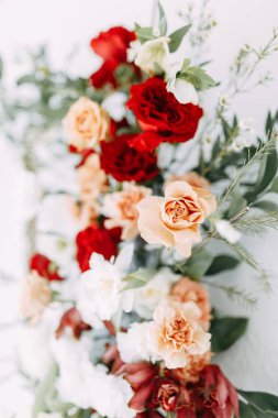 Şık bir düğün töreni süsü. Kemerin süslemesi kırmızı güller ve düğün çiçekçisi. Düğün buketlerindeki modern trendler. 