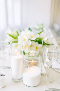 Güzel sanatlar tarzında hafif dekorlar. Kompozisyonda gözlük ve laleler var. Ziyafet için masa hazırlıyorum. Beyaz Stüdyoda düğün masası dekorasyonu. 