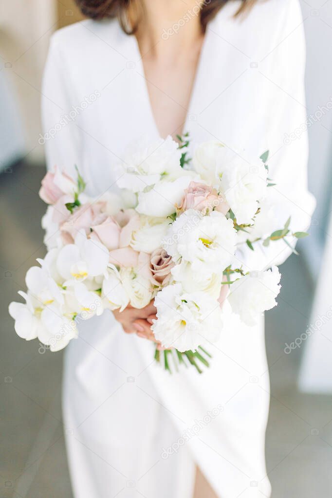  Floristics in the style of fine art in Europe. Light bouquet of peonies and roses. Modern wedding bouquet in the hands of the bride.