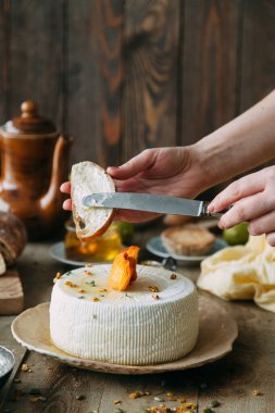 Ekmek ve tereyağı, bıçaklı eller. Masada dilimlenmiş beyaz ekmek. 