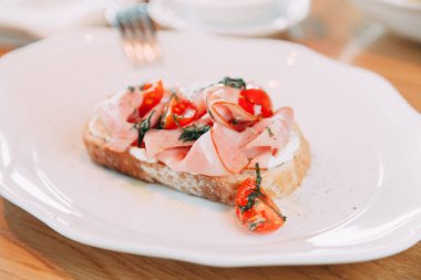 Taze ekmek ve domatesli ekmek. Pastırmalı bir tabak. 