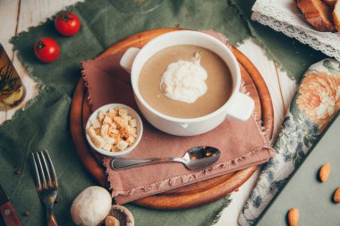  Lokantadan alınmış tabakla düz kompozisyon. Ekmek kırıntılı mantar çorbası püresi..
