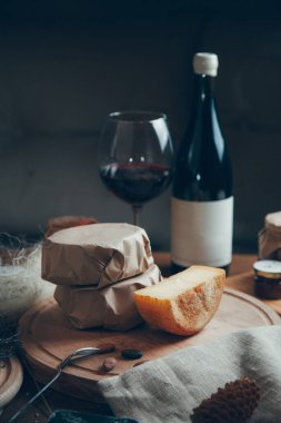 Şarap ve bardakla sert peynirden oluşan pürüzsüz bir daire. Tahta üzerinde çiftlik peynirleri. Dilimlenmiş peynirle hayat. 