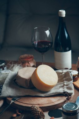 Şarap ve bardakla sert peynirden oluşan pürüzsüz bir daire. Tahta üzerinde çiftlik peynirleri. Dilimlenmiş peynirle hayat. 