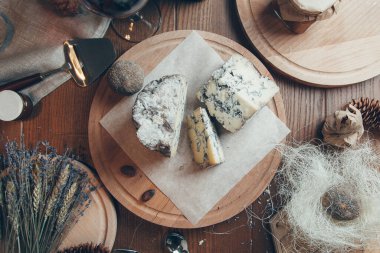 Şarap ve yassı peynirli kompozisyon. Ahşap bir tahtanın üzerinde mavi asil küflü peynir.. 