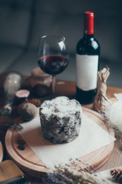 Şarap ve yassı peynirli kompozisyon. Ahşap bir tahtanın üzerinde mavi asil küflü peynir.. 