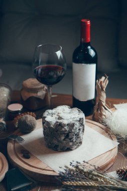 Şarap ve yassı peynirli kompozisyon. Ahşap bir tahtanın üzerinde mavi asil küflü peynir.. 