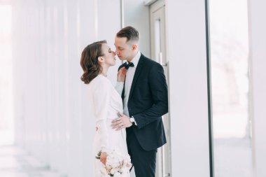 Gelin ve damadın romantik fotoğraf çekimi. Yeni evliler birlikte mutlular. Aydınlık bir iç mekanda modern bir çift.. 