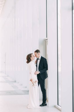 Gelin ve damadın romantik fotoğraf çekimi. Yeni evliler birlikte mutlular. Aydınlık bir iç mekanda modern bir çift.. 