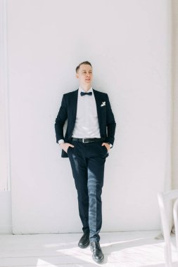  Tarafsız bir arkaplanda ceketli bir adamın portreleri. Mutlu damadın zarif portreleri..