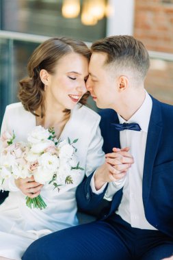 Gelin ve damadın romantik fotoğraf çekimi. Yeni evliler birlikte mutlular. Aydınlık bir iç mekanda modern bir çift.. 