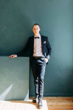  Tarafsız bir arkaplanda ceketli bir adamın portreleri. Mutlu damadın zarif portreleri..