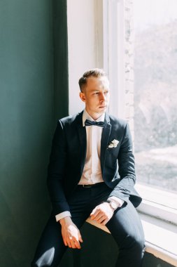  Tarafsız bir arkaplanda ceketli bir adamın portreleri. Mutlu damadın zarif portreleri..