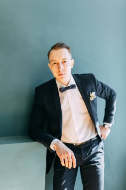  Tarafsız bir arkaplanda ceketli bir adamın portreleri. Mutlu damadın zarif portreleri..